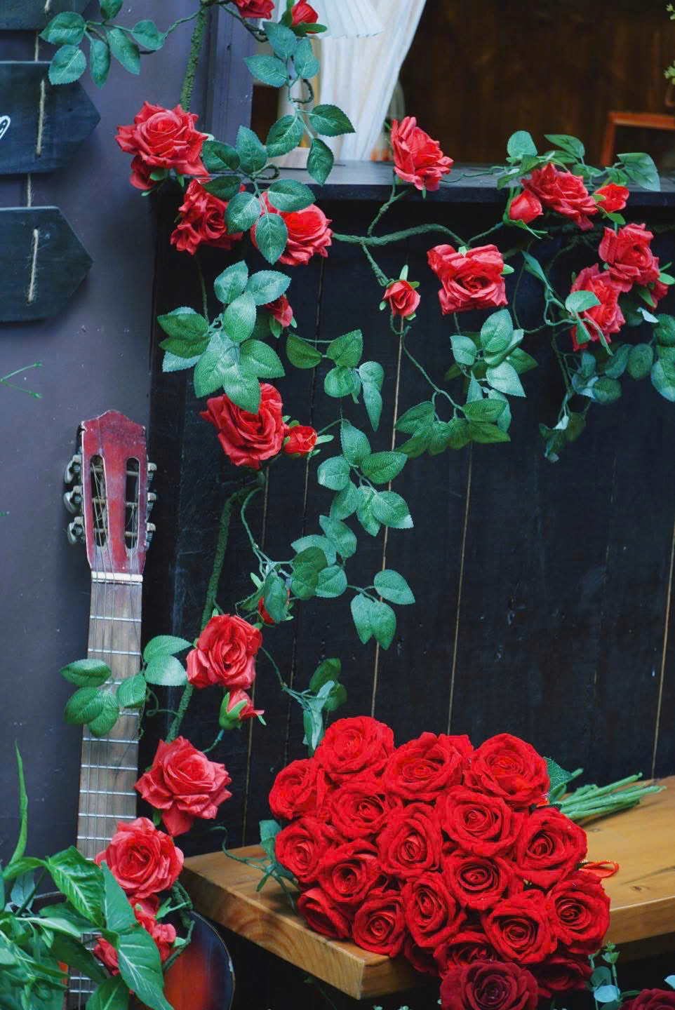 Góc chụp ảnh nghệ thuật với guitar và hoa hồng đỏ tại Thím's House